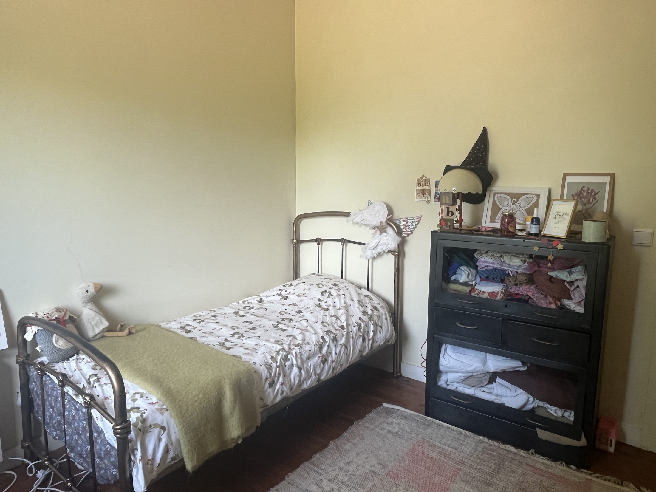 Single bedroom with iron bed frame and wooden floors